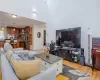 Living area featuring high vaulted ceiling, a healthy amount of sunlight, light wood finished floors, and a chandelier