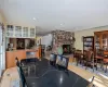 Kitchen featuring a sink, decorative backsplash, appliances with stainless steel finishes, wall chimney range hood, and brown cabinets