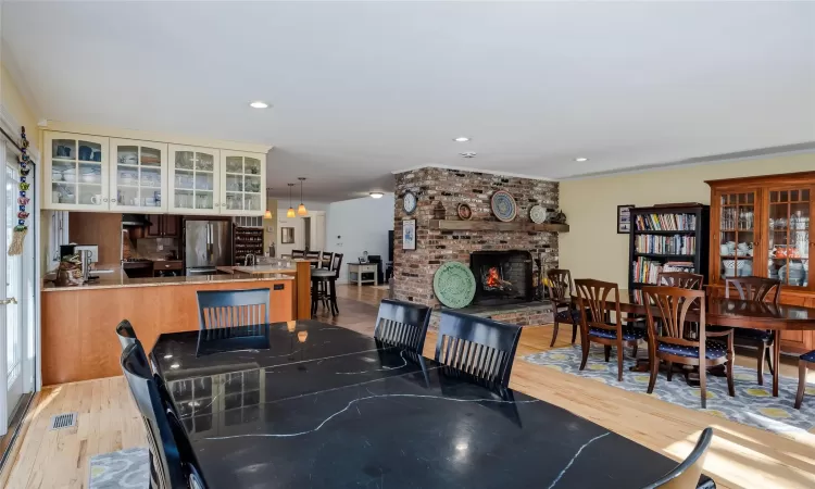 Kitchen featuring a sink, decorative backsplash, appliances with stainless steel finishes, wall chimney range hood, and brown cabinets