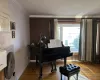 Living area featuring wood finished floors, baseboards, and ornamental molding