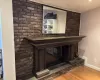 Details featuring a brick fireplace, wood finished floors, and baseboards