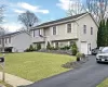 Split foyer home with aphalt driveway, an attached garage, and a front lawn