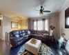 Living area featuring crown molding, dark wood-type flooring, and ceiling fan