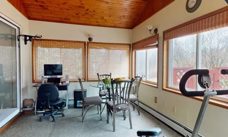 Sunroom featuring a baseboard radiator, wood ceiling, and vaulted ceiling