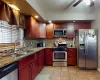 Kitchen featuring decorative backsplash, dark stone countertops, appliances with stainless steel finishes, and a sink