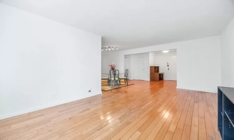 Unfurnished living room with baseboards and light wood-type flooring