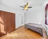 Bedroom featuring light wood-type flooring, radiator, and ceiling fan