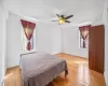 Bedroom with light wood-style flooring, radiator, a ceiling fan, and baseboards