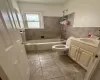 Full bathroom featuring toilet, tile walls, vanity, and  shower combination