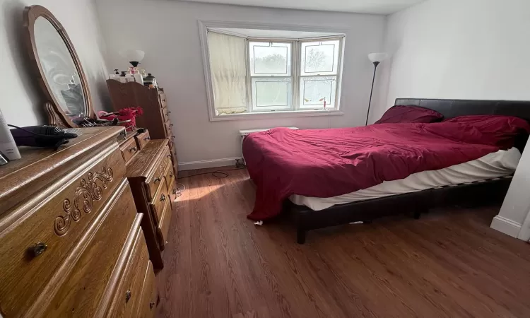 Bedroom featuring baseboards and wood finished floors