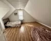 Bedroom with radiator, baseboards, lofted ceiling, wood finished floors, and a textured ceiling