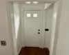 Doorway featuring baseboards and dark wood-style flooring