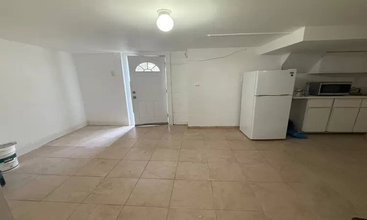 Entryway with light tile patterned floors and baseboards