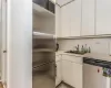 Kitchen featuring white cabinetry, a sink, light countertops, stainless steel appliances, and light tile patterned flooring