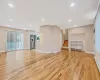 Unfurnished living room featuring baseboards, stairway, light wood-type flooring, baseboard heating, and recessed lighting