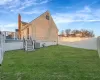 View of side of property with central AC unit, a wooden deck, a yard, a fenced backyard, and a chimney