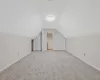 Bonus room featuring baseboards, light colored carpet, and vaulted ceiling