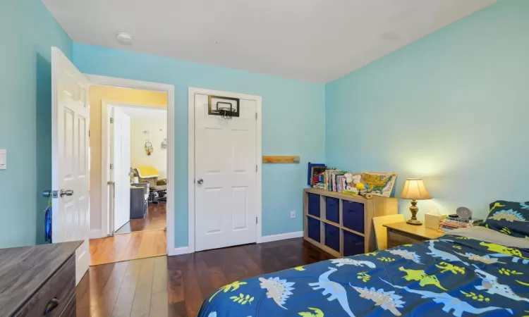 Bedroom with wood finished floors and baseboards