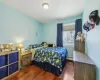 Bedroom with dark wood-style floors and a baseboard radiator