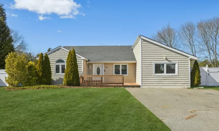 View of front of house with a shingled roof, a front lawn, fence, driveway, and a gate