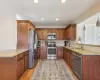 Kitchen with decorative backsplash, light wood-style flooring, appliances with stainless steel finishes, an island with seating