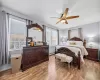 Bedroom featuring light wood-style flooring, a ceiling fan, baseboards, and a baseboard radiator