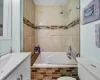 Bathroom with toilet, vanity, and tiled shower / bath