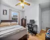 Bedroom with baseboards, light wood-style floors, and a ceiling fan