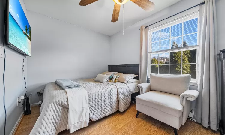 Bedroom featuring baseboards, wood finished floors, and a ceiling fan