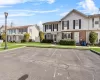 Townhome / multi-family property featuring entry steps, a residential view, uncovered parking, a front yard, and brick siding