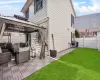 View of side of home with a gazebo, a patio, a lawn, and fence