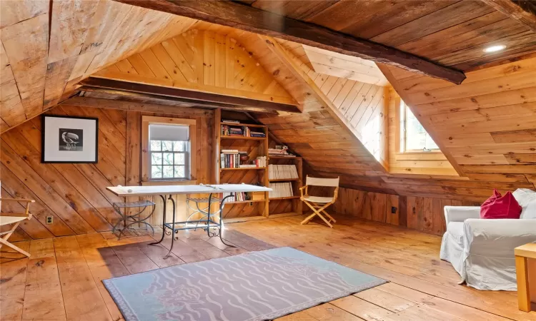 Unfurnished office with hardwood / wood-style floors, vaulted ceiling with beams, wood walls, and wooden ceiling