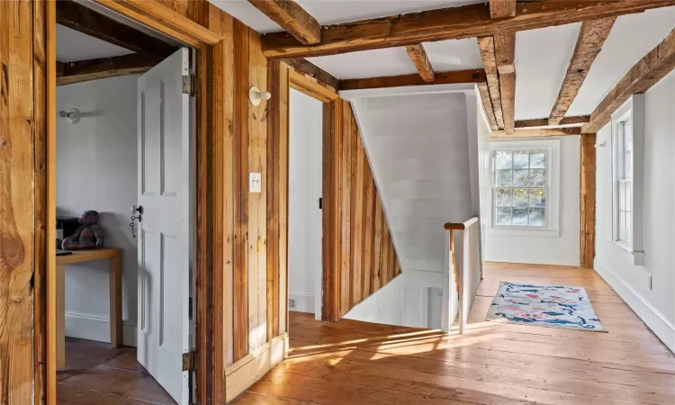 Hall with beam ceiling and hardwood / wood-style floors