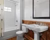 Bathroom with a sink, shower / bathtub combination with curtain, and toilet