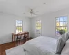 Bedroom with cooling unit, multiple windows, baseboards, and wood finished floors