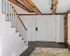 Entryway with stairs, beam ceiling, wood finished floors, and baseboards