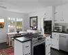 Kitchen featuring dark countertops, appliances with stainless steel finishes, and white cabinetry