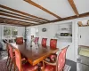 Dining area with dark wood finished floors and beam ceiling