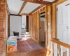 Hall featuring stairs, beam ceiling, wood walls, and wood-type flooring