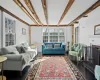 Living area with beam ceiling, a fireplace, and wood finished floors