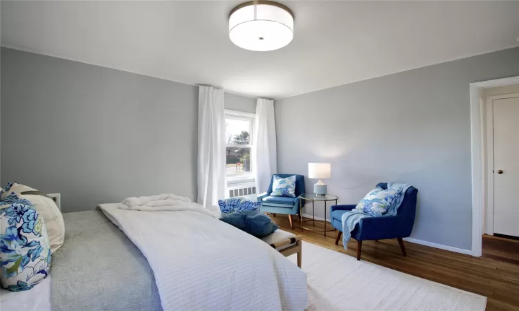 Bedroom with wood finished floors and baseboards