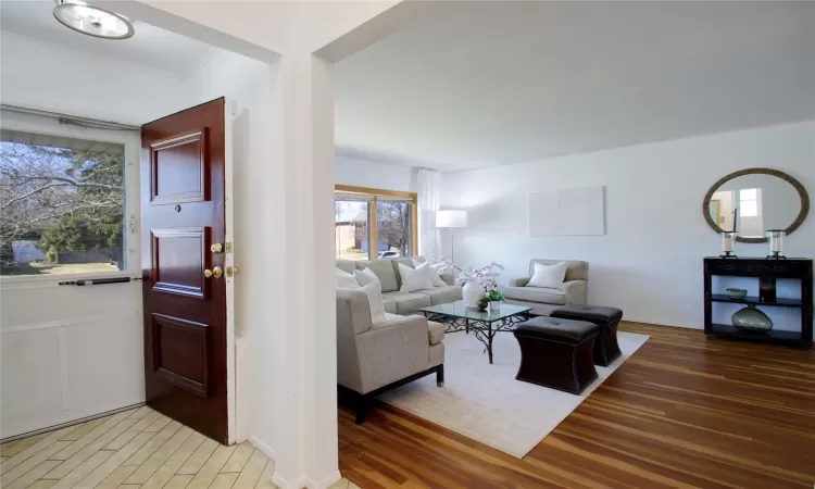 Living room with crown molding, baseboards, and wood finished floors