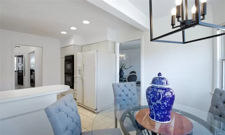 Dining area with recessed lighting, a notable chandelier, light tile patterned flooring, and crown molding