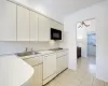 Kitchen featuring black appliances, a sink, crown molding, light countertops, and light tile patterned floors