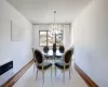 Dining space featuring heating unit, wood finished floors, baseboards, an inviting chandelier, and ornamental molding