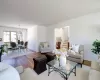 Living room featuring stairs, a notable chandelier, baseboards, and light wood finished floors