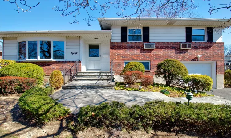 Split level home featuring brick siding and an attached garage