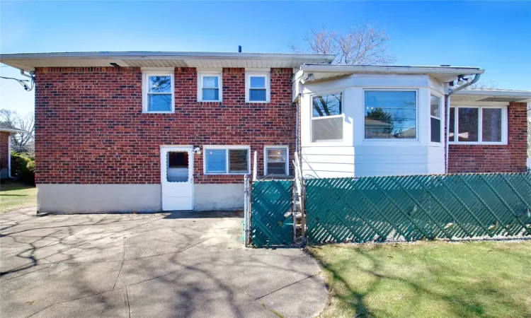 View of front of house featuring brick siding, a gate, and fence