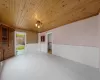 Empty room with wooden ceiling and a wainscoted wall