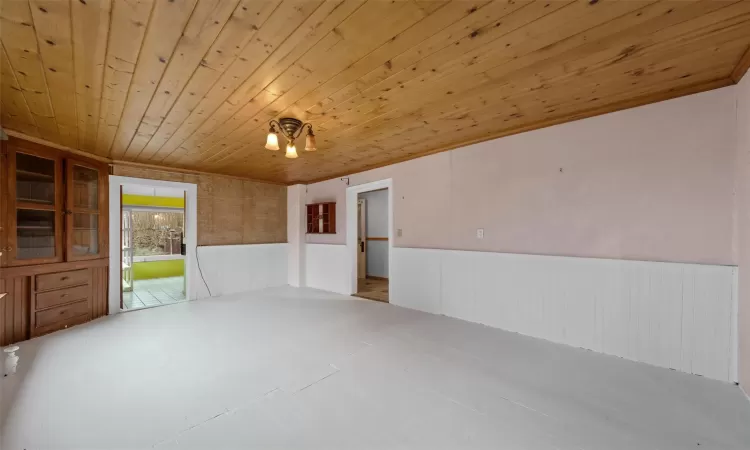 Empty room with wooden ceiling and a wainscoted wall